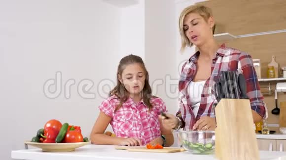 妈妈和女儿在厨房切了一个甜的红嘴视频的预览图