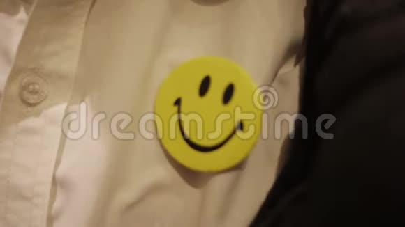 一个在办公室工作到深夜的男人穿的白色衬衫上的黄色微笑徽章视频的预览图