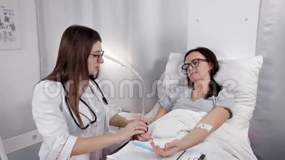 一位年轻的女医生在病房里检查病人看着她那令人震惊的双手检查视频的预览图