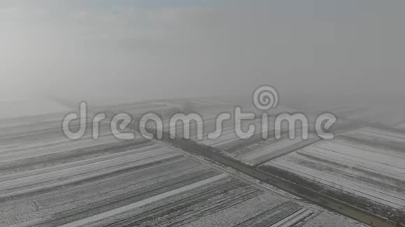 冬天来了空中视野的田野覆盖着雪和旧墓地附近的道路视频的预览图