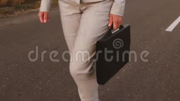 商务女性手里拿着黑色公文包在路上穿着裤子和夹克特写视频的预览图