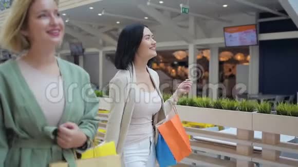 女孩在购物中心画廊里散步和聊天视频的预览图