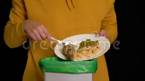 女人用盘子刮一个鸡腿米饭青豆放进垃圾桶视频的预览图