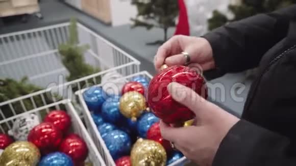 女孩手里拿着一个新年玩具红色的球为圣诞节买新玩具视频的预览图