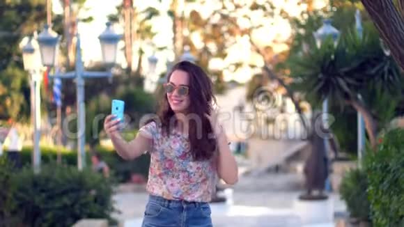 布鲁内特女孩摆姿势自拍照片在热带城市快乐女孩自拍视频的预览图