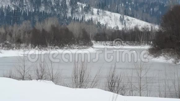冬天的河水在寒冷的露天山脉的背景上流动视频的预览图
