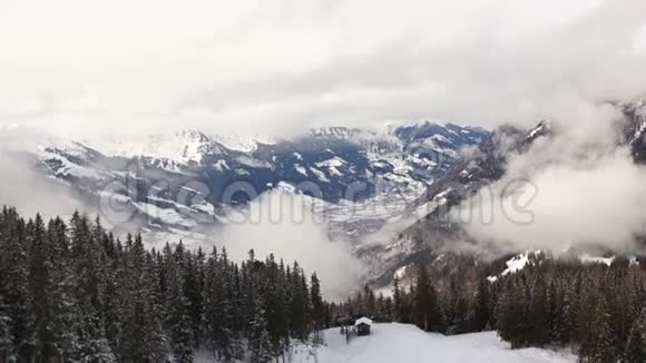 美丽的山景全景拍摄白雪覆盖的阿尔卑斯山和高云杉一个女孩正在山上休息视频的预览图