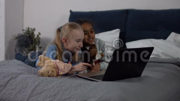 快乐的多种族女孩享受笔记本电脑卡通视频的预览图