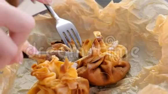 女人正在吃朱莉安烘焙的面团放在面包纸上上面有茶和黄油双手特写视频的预览图