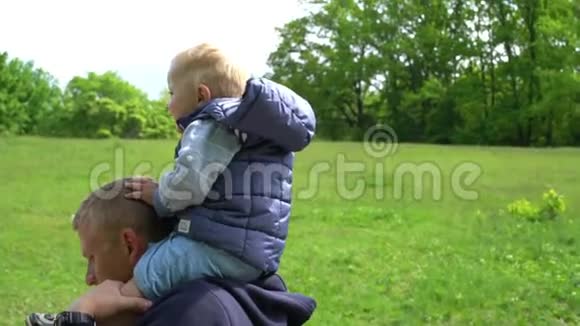 儿子坐在他父亲的脖子上公园里父亲天特写镜头视频的预览图