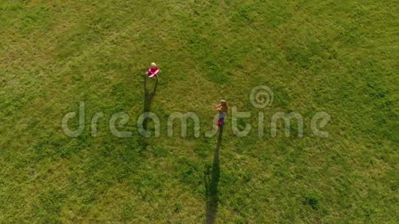 一位年轻女子和她的小儿子在公园里玩塑料飞机的俯视镜头视频的预览图