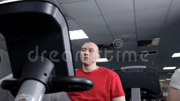 健身者在健身房里用固定自行车健身视频的预览图