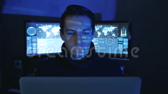 在一个充满监控屏幕的数据中心一个男性专业IT程序员的特写肖像哈克在工作视频的预览图