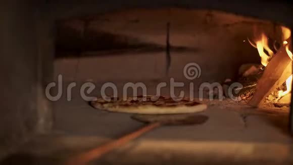 厨师检查烤箱里辣香肠披萨的准备情况视频的预览图