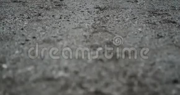 拍摄了一个男子在雨天海边的录像他手上拿了一些湿沙扔了下去视频的预览图