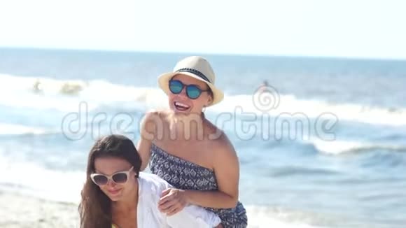 两个女朋友在海滩上玩得很开心暑假戴太阳镜戴草帽到处胡闹视频的预览图
