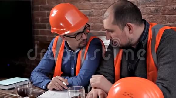 两个工程师坐在桌边喝咖啡聊天做笔记视频的预览图
