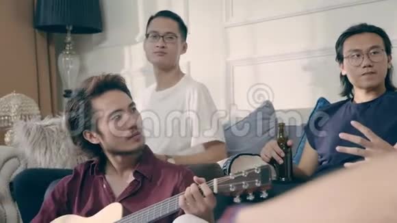 年轻的亚洲音乐家放松地喝啤酒视频的预览图