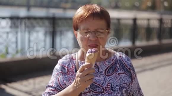 站在海滨的一位老妇人拿着华夫饼锥吃冰淇淋的画像视频的预览图