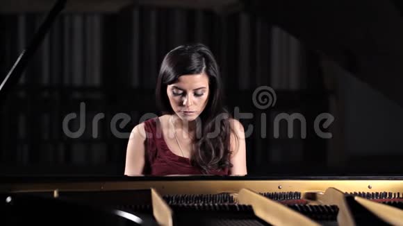 一个年轻女孩弹钢琴音乐会前排练古典音乐视频的预览图