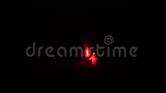 手里拿着红火的宇航员在一个未知的空间里行走在黑暗中宇航员的轮廓可以看到视频的预览图