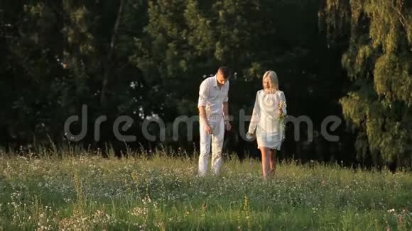 一对恩爱夫妻正沿着草坪散步视频的预览图