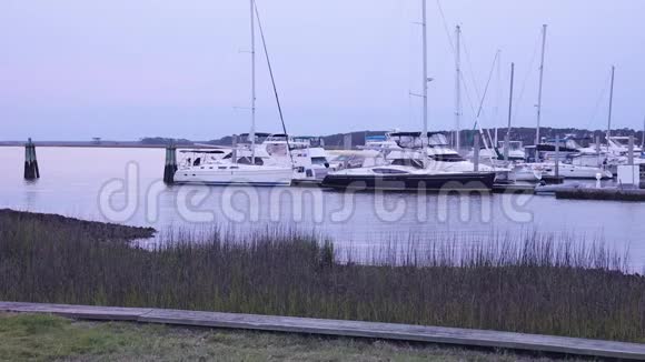 在日出前的清晨可以看到许多停泊的帆船在小港的宁静景色慢动作视频的预览图