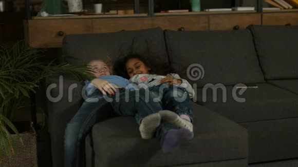 两个多种族的小女孩在沙发上玩耍视频的预览图