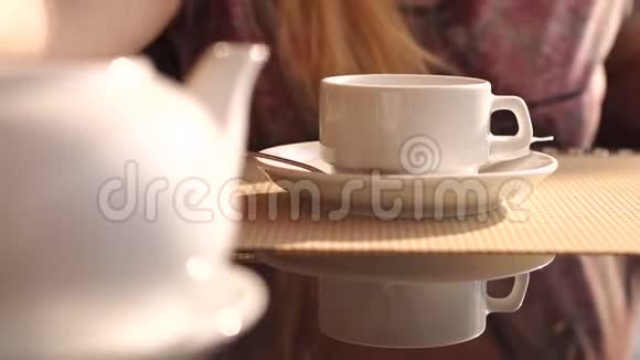 女孩把茶从茶壶里倒进杯子里特写视频的预览图