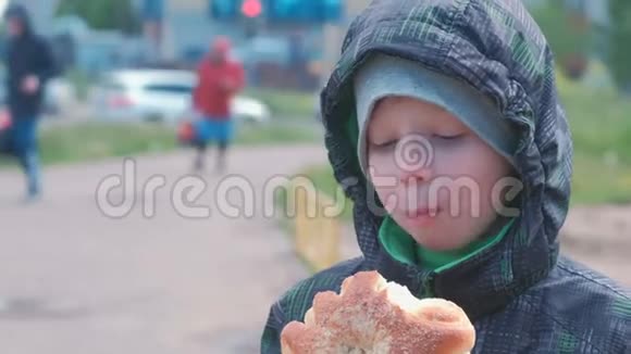 在街上吃面包的男孩视频的预览图