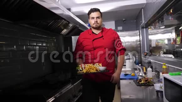 厨师从厨房拿出一盘三明治和炸薯条视频的预览图