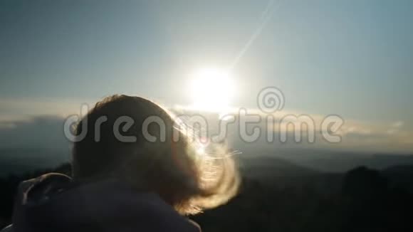 女人在日落背景下头发的缓慢运动视频的预览图