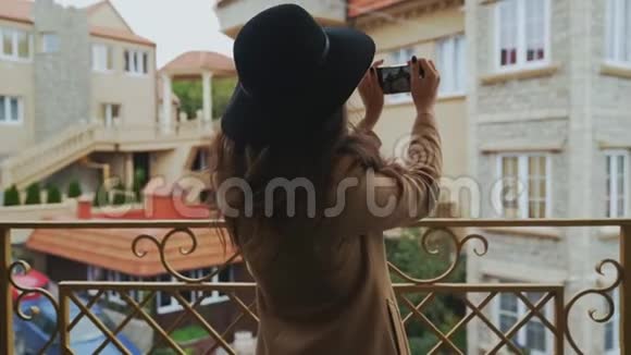 从后面看特写镜头穿着外套和帽子的斯特迪坎苗条的女人在城市里走来走去拍了一张照片视频的预览图
