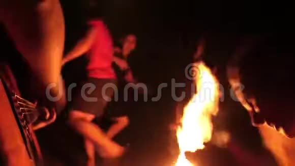 快乐的朋友跳舞晚上在篝火旁用吉他唱乐歌视频的预览图