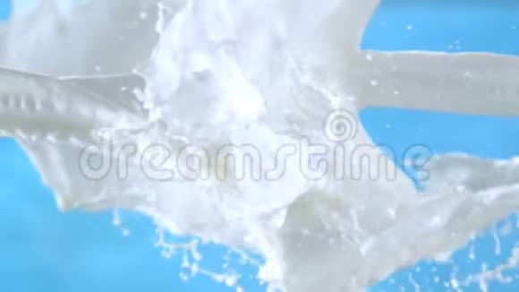 新鲜牛奶在1500fps时蓝色背景下的空气溅起视频的预览图