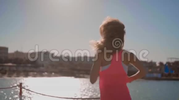 一个年轻的女孩在日落时沿着大海奔跑视频的预览图