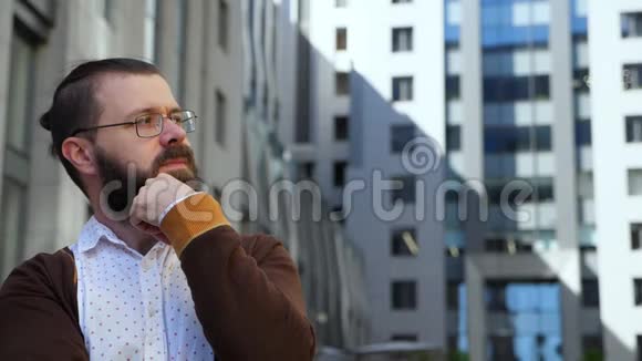 一个戴眼镜的留胡子的人左顾右盼把他的胡须抚平他摘下眼镜凝视远方TT视频的预览图
