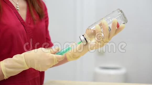 一位身穿红色医用衣服的红头发的年轻护士从玻璃瓶中拨入一次性注射器视频的预览图