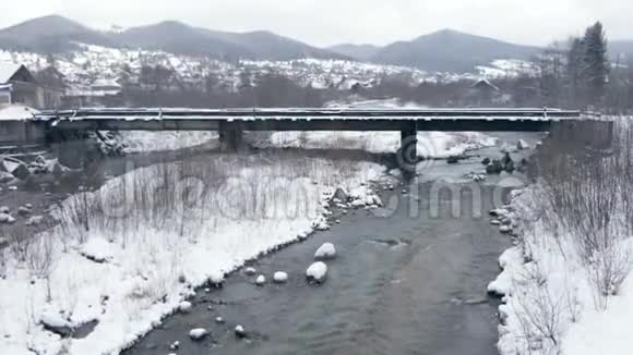 斯洛莫冬季喀尔巴阡山脉一座桥下的狭窄溪流视频的预览图