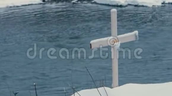 冬天木十字架立在布科维尔的河岸上视频的预览图