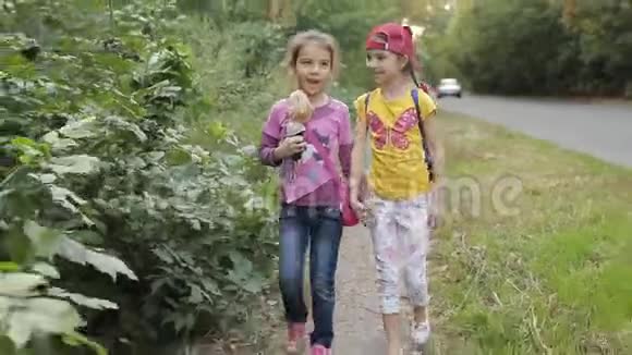 两个小女孩走在路边谈笑风生视频的预览图