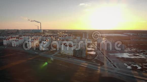 在夕阳和烟斗的映衬下从空中拍摄到城市的一个新居民区视频的预览图