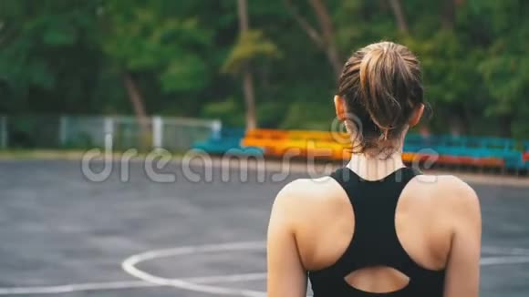 在公园的运动场上年轻运动员女子沿着运动场散步后景视频的预览图