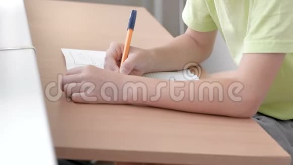 学校的孩子学会坐在桌子旁写字母特写男孩手视频的预览图