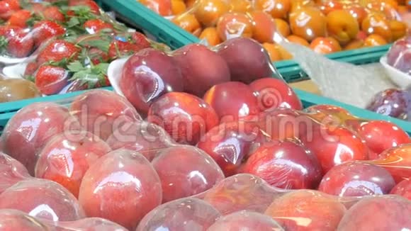 在街道市场柜台上用特殊玻璃纸布保护桃子尼达林杏子草莓猕猴桃不受污染视频的预览图