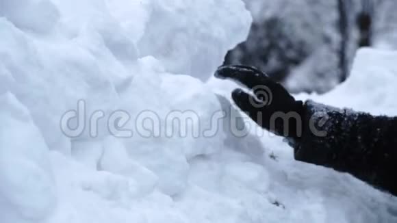 男人戴着黑色手套用雪片搭建了一座冰屋视频的预览图