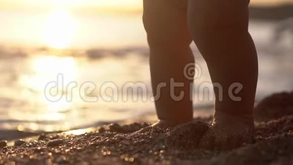 可爱的特写镜头的婴儿的腿站在海滩上视频的预览图