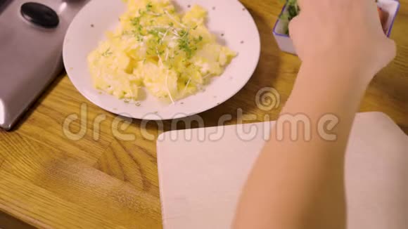 女人正在切小番茄把它们和炒鸡蛋放在厨房的白板上视频的预览图