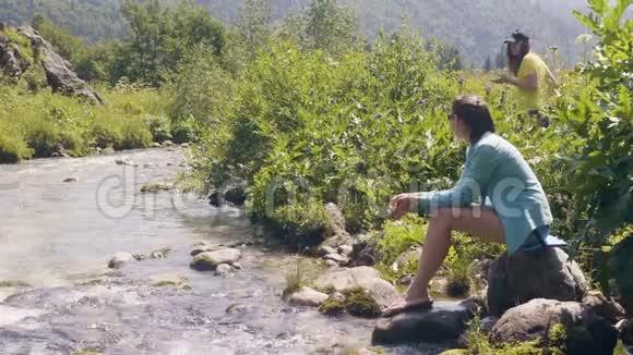 年轻女子坐在河岸上夏天休息视频的预览图