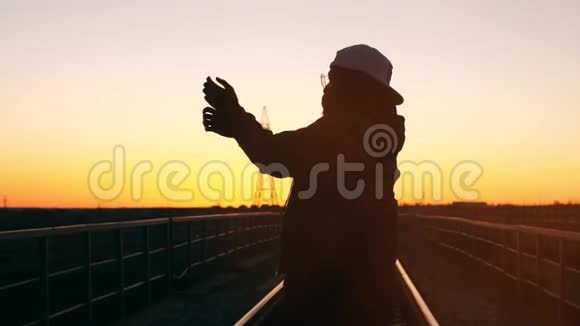 日落时跳舞的男人的剪影视频的预览图